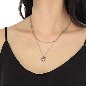 Détail d'un collier double rang en acier inoxydable argenté avec pendentif cœur sur modèle