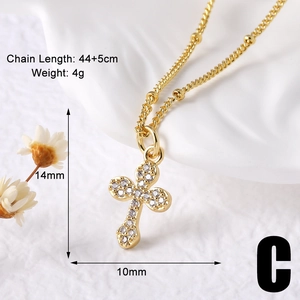 Detailed macro view showing the 14x10mm gold cross pendant set with white zircon stones