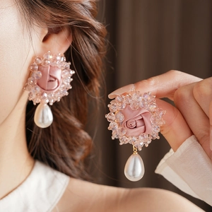 Close-up of elegant pink silk rose earrings with crystal beads and teardrop pearls