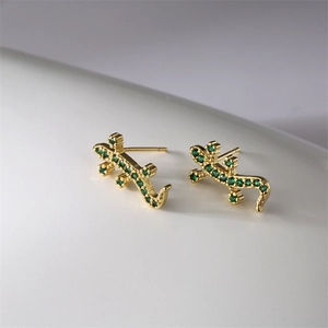 Detailaufnahme der goldenen Gecko-Ohrstecker mit mikrobearbeiteten grünen Zirkonia