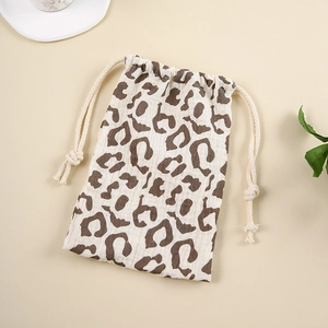 Close-up of leopard print cotton drawstring storage bag with natural muslin texture