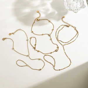 Elegant gold-plated finger bracelets with zircon stones displayed on a clean white surface