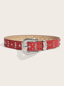 Close-up of red lychee leather belt with butterfly rhinestone buckle and metal studs