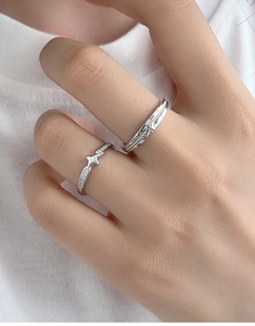 Detail of S925 sterling silver couple rings set with star charms and sparkling stones