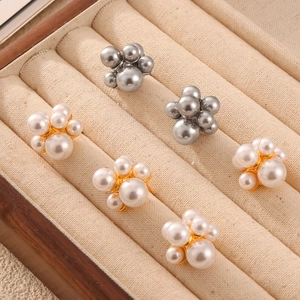 Elegant irregular cluster pearl earrings with gold metal base on a jewelry display tray
