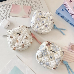 Flat lay of quilted cotton sanitary napkin pouches with bear and star prints on a desk