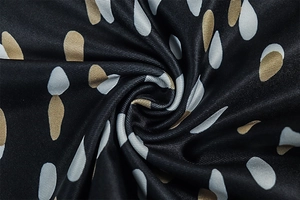Macro detail of high-quality black textile with gold, white and grey raindrop patterns