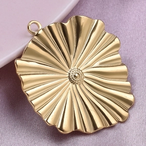 Detail of flower shaped 304 stainless steel pendant with textured gold finish