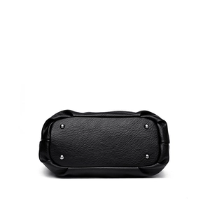 Vista fondo borsa tote in pelle nera con quattro piedini protettivi in metallo lucido