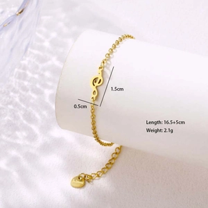 Detailed view of music note charm on gold stainless steel chain with size measurements