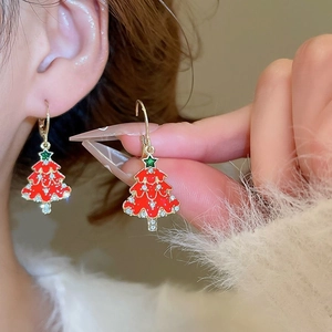 Close-up of Christmas tree drop earrings with enamel finish and sparkling crystals on ear