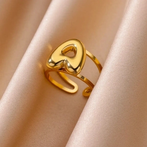 Macro shot of bubble letter A ring in gold finish on silk background showing fine details