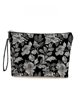 Détail d'une trousse à maquillage à motif floral avec fermeture éclair et dragonne