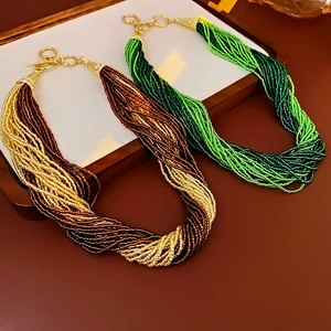Detail of multi-strand seed bead necklaces with gold T-bar toggle clasp and twisted design