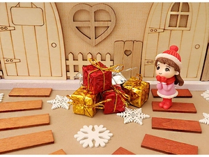 Miniature Christmas scene with a girl doll, red gift boxes, and festive snow decorations