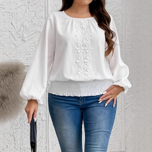 Detail of white long sleeve blouse featuring floral lace panels and puff sleeve cuffs