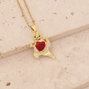 Golden panda necklace with red heart zircon pendant on a textured stone background