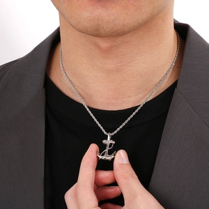 Close-up of a silver nautical anchor pendant with a twisted chain on a male model