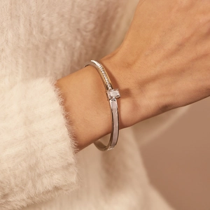 Detail of silver stainless steel bangle with square zircon and mother of pearl inlay