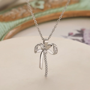 Elegant gold-plated bow pendant necklace with sparkling cubic zirconia on a fine chain