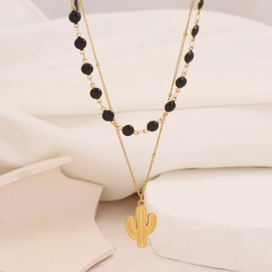 Detail of gold double-layered necklace with black beads and cactus pendant