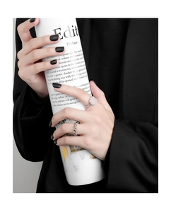 Detailed view of silver bead ring and irregular gemstone ring on model's hand