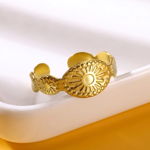 Detailed close-up of gold stainless steel open ring with solar sunburst relief design