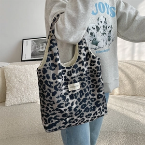 Detail of leopard print canvas tote bag featuring a white woven label and spacious interior