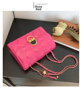 Detail of rose red quilted crossbody bag with gold twist lock and chain strap