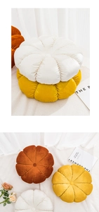Close-up of plush pumpkin cushions in white, yellow, and brown on a soft rug