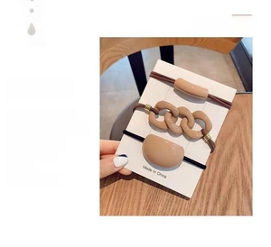 Detailed view of hair elastics with acrylic ornaments in beige and brown tones