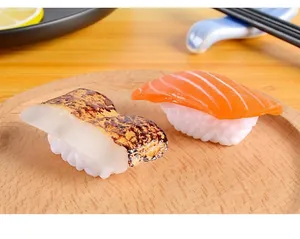 Detailed macro view of realistic PVC salmon and grilled sushi models on a wooden tray