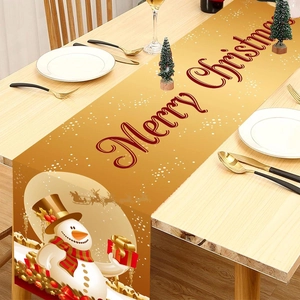 Golden Christmas table runner featuring snowman and Santa Claus patterns on wooden table