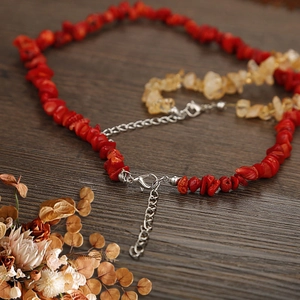 Macro shot of natural red and yellow crystal stone necklaces with silver lobster clasp