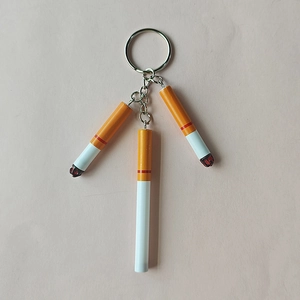 Miniature cigarette keychains with realistic filters and burnt ends on a pink background