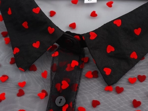 Detail of black mesh collar and red heart flocking pattern on a sheer stylish blouse