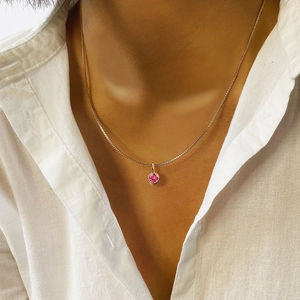 Detailaufnahme einer goldenen Edelstahlhalskette mit rosa Geburtsstein-Anhänger