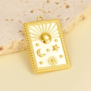Détail macro du pendentif doré en acier avec motifs soleil et lune en relief sur pierre