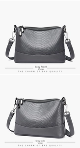 Close-up of grey snake-embossed PU leather bag with top double zippers and metal hardware