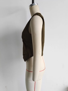 Detail view of the asymmetrical button-up vest in olive green on a mannequin