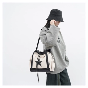 Detail of canvas bucket bag with black star print, drawstring closure and shoulder straps