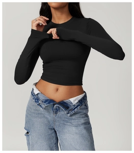 Detail shot of black tight-fit long sleeve yoga top with crew neck and cropped design