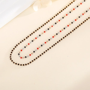Dettaglio di una collana boho fatta a mano con pietre colorate e maglie a catena d'oro