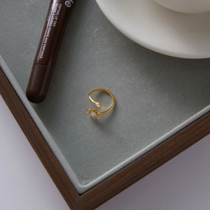 Close-up of gold adjustable ring with sparkling starburst and round zircon details