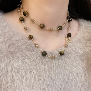 Detail einer mehrlagigen Halskette mit Tigerauge-Steinen, Perlen und Gold-OT-Verschluss