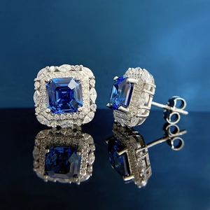 Macro shot of royal blue square sapphire earrings with double halo marquise diamond clusters