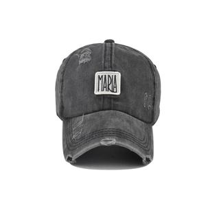 Detail of vintage washed dark gray cotton baseball cap with MARIA letter patch and distressed holes