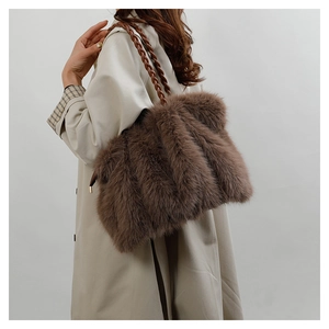 Detail of a brown faux fur tote bag featuring a stylish woven leather strap
