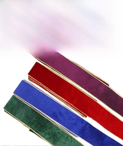 Detailed view of Christmas velvet ribbons with gold edges in red, blue, and green