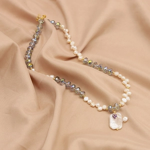 Baroque pearl necklace with square branch pendant and crystals on soft silk fabric